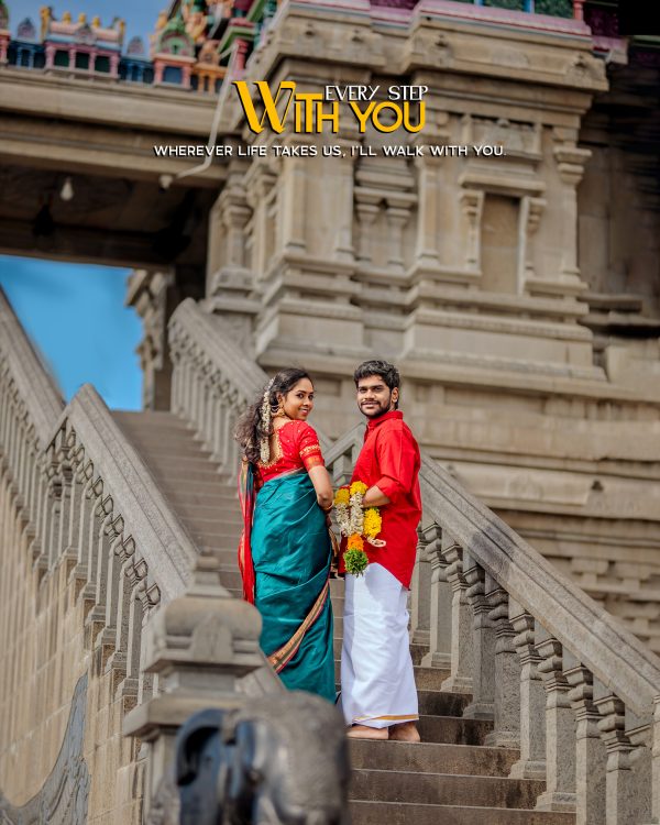 A couple in traditional Indian attire stands on a stone staircase with ornate temple architecture in the background, facing the camera warmly.